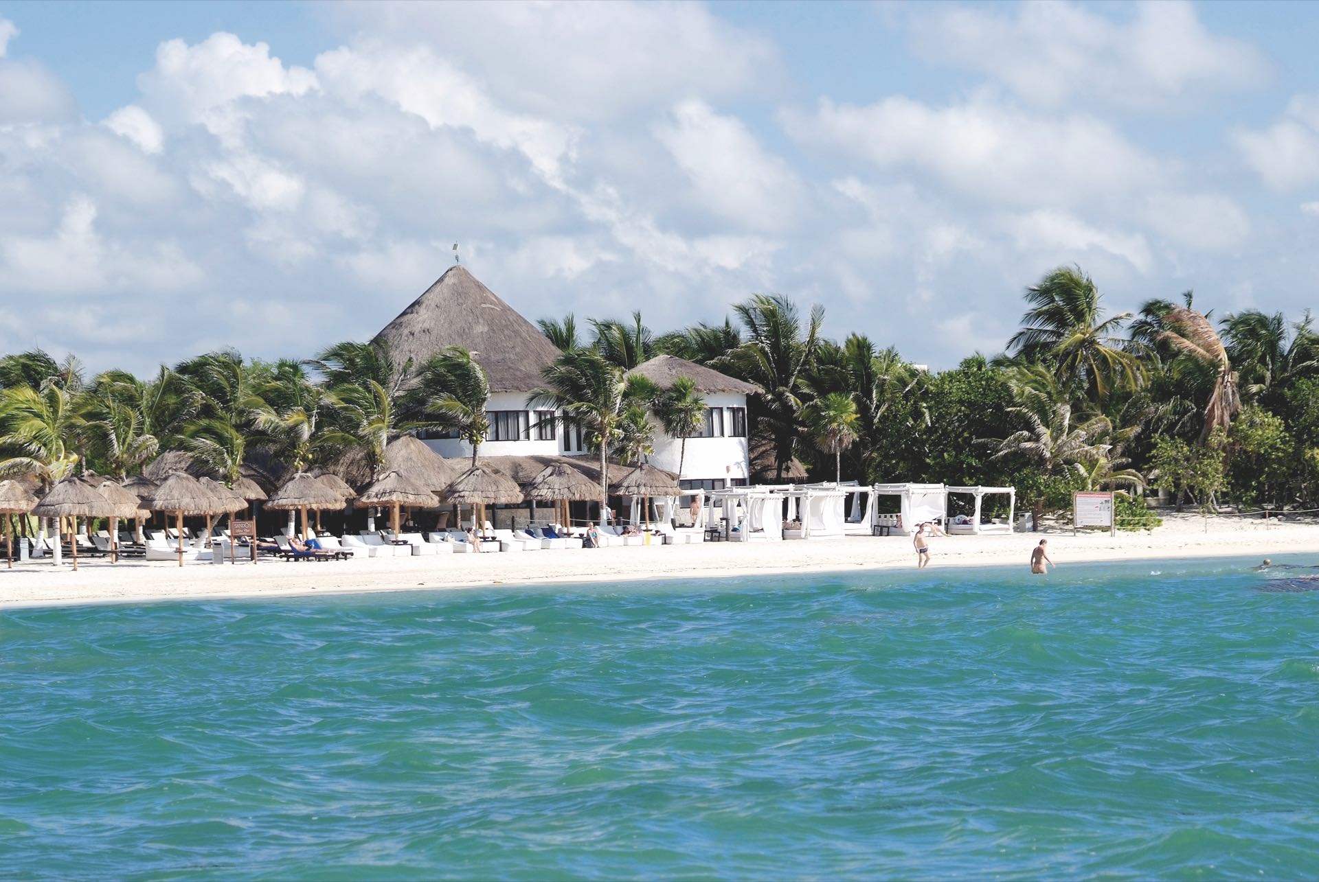 Tropisch resort met ligbedden aan het strand